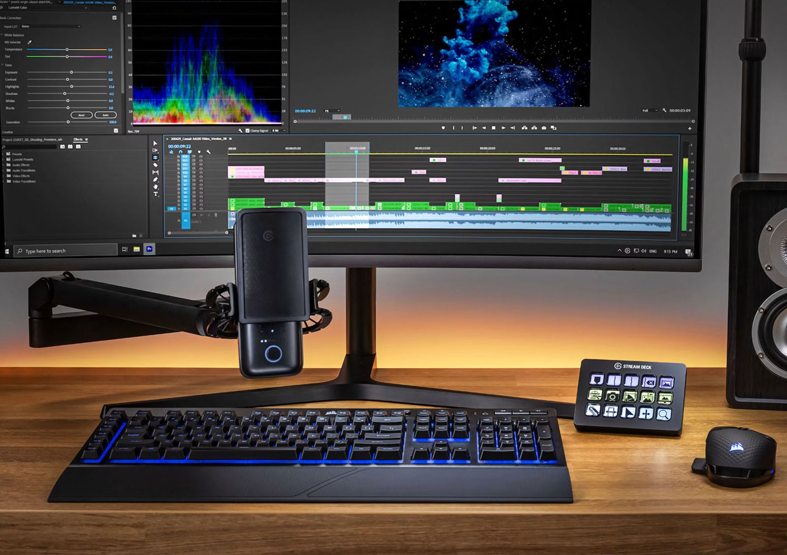 A video editing setup with a Stream Deck beside the keyboard and a microphone below the monitor