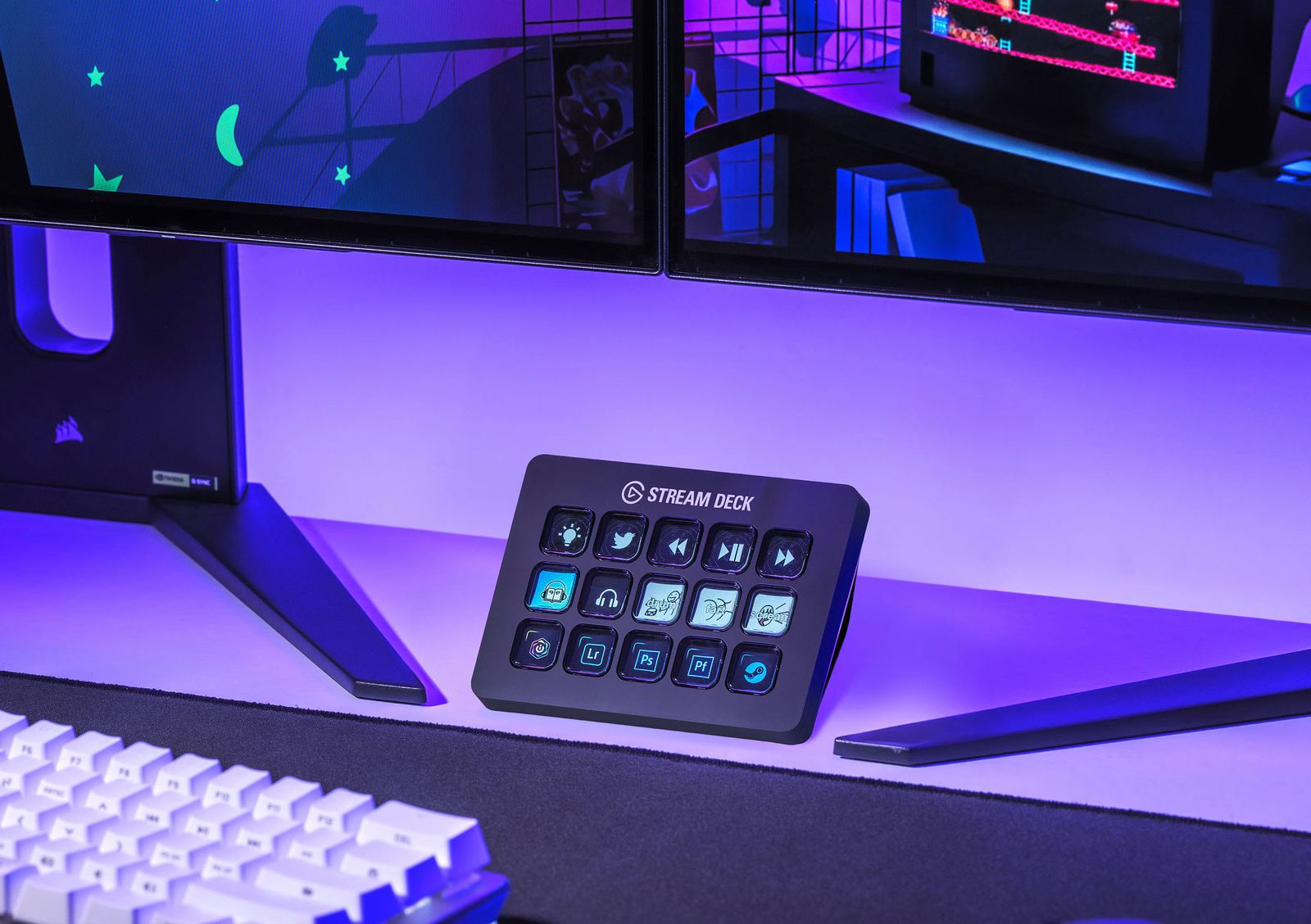 A Stream Deck with fifteen lit keys on a desk under purple light, in front of a monitor