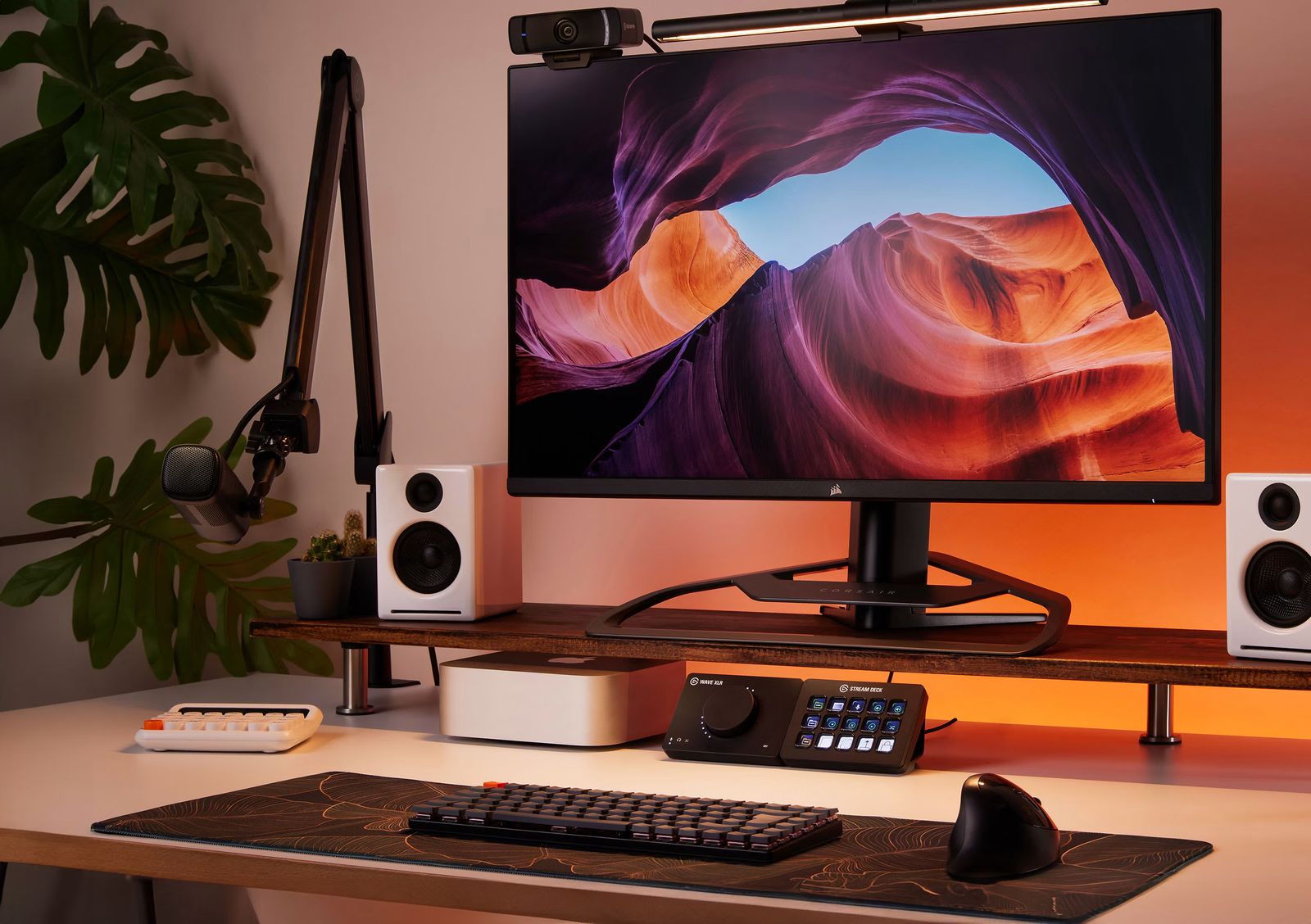 A tidy desk setup with a monitor, speakers and a small Stream Deck in warm evening light